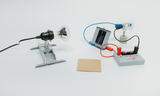Das Bild zeigt verschiedene Experimentiergeräte für technische und physikalische Experimente, darunter eine Lampe, ein Solarpanel und eine kleine Windturbine. Diese Geräte sind auf einem weißen Untergrund angeordnet, um die Lernumgebung zu verdeutlichen.