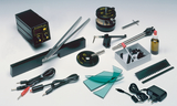 Das Bild zeigt eine Sammlung von Experimentiergeräten und Zubehör, die für Bildungszwecke bestimmt sind. Zu den abgebildeten Gegenständen gehören ein Stroboskop, verschiedene Kabel, Gläser, ein Messgerät und Werkzeuge, die für praktische Experimente verwendet werden können.