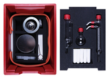 Das Bild zeigt eine rote Aufbewahrungsbox, die mit verschiedenen Experimentiermaterialien ausgestattet ist. In der Box befinden sich unter anderem Glasgeräte, Schläuche und ein Metallteil, die für chemische Experimente im Bildungsbereich verwendet werden können.