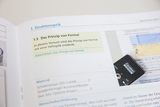 Das Bild zeigt eine Seite aus einem Lehrbuch über Strahlenoptik, das sich mit dem Prinzip von Fermat beschäftigt. Es enthält Informationen zu einem Experiment, Materialien sowie eine Skizze, die die Anwendung des Prinzips veranschaulicht.