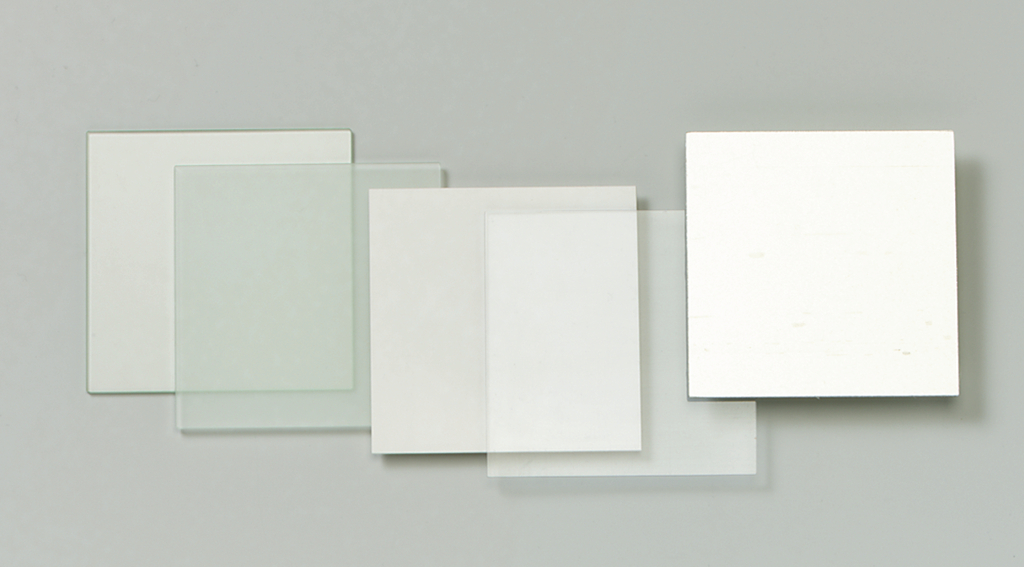 Das Bild zeigt mehrere durchsichtige und opake Platten aus Glas oder Kunststoff, die in verschiedenen Größen angeordnet sind. Diese Materialien könnten für Experimente oder Bildungszwecke im naturwissenschaftlichen Unterricht verwendet werden.