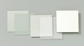 Das Bild zeigt mehrere durchsichtige und opake Platten aus Glas oder Kunststoff, die in verschiedenen Größen angeordnet sind. Diese Materialien könnten für Experimente oder Bildungszwecke im naturwissenschaftlichen Unterricht verwendet werden.
