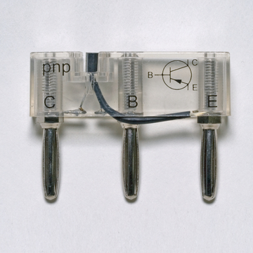 Das Bild zeigt ein transparentes Bauteil mit der Bezeichnung "pnp" und den Anschlüssen C, B und E, das wahrscheinlich einen Transistor darstellt. Es ist mit Metallstiften ausgestattet, die für elektrische Verbindungen dienen.