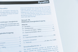 Das Bild zeigt eine Anleitung für ein Experiment mit dem Titel "Elektrische Energieübertragung", das im Rahmen von Schulversuchen durchgeführt werden kann. Es werden Materialien wie DynaMot, Tischklemmen und weitere Komponenten aufgelistet, die für das Experiment benötigt werden.
