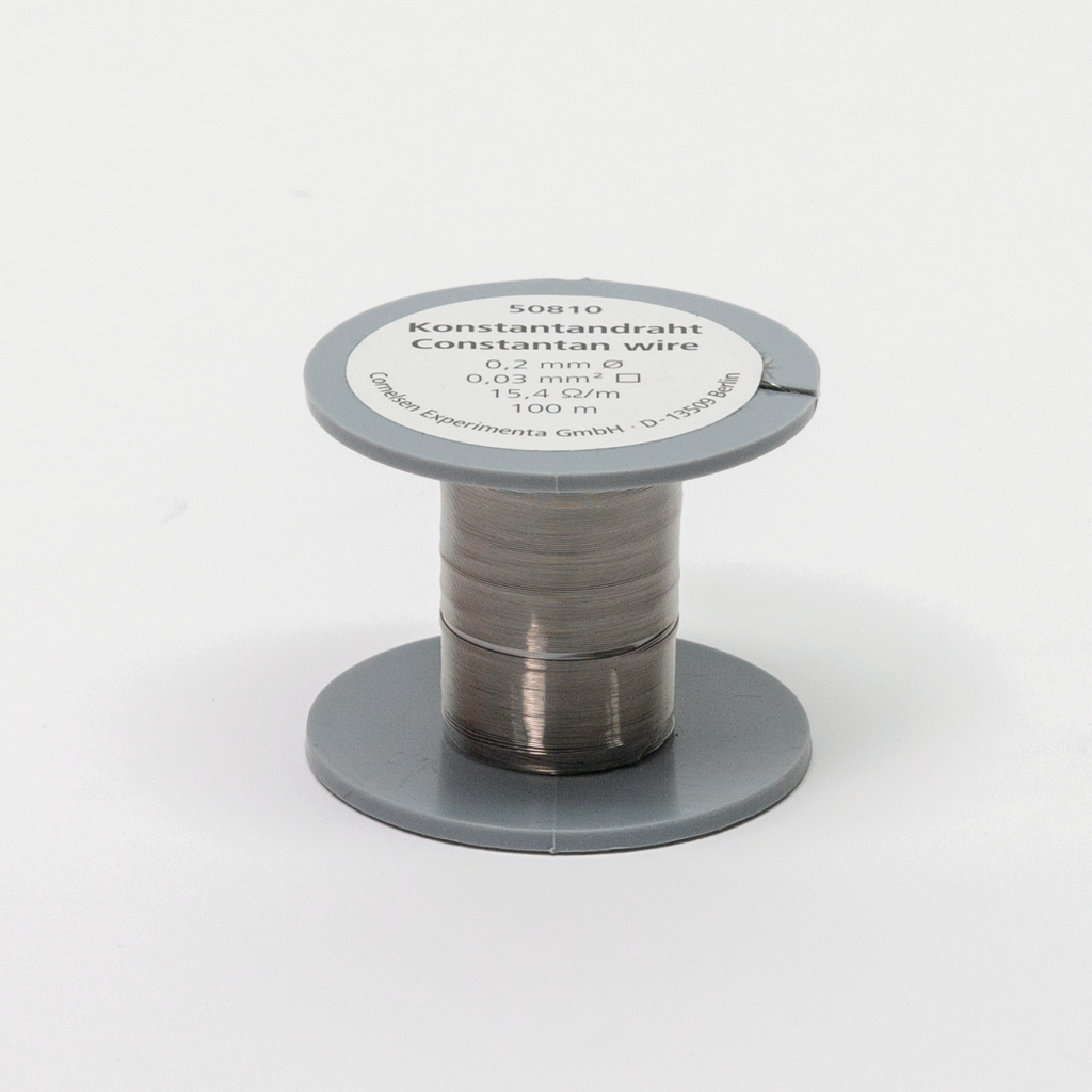 Das Bild zeigt eine Rolle Konstantandraht mit einem Durchmesser von 0,2 mm und einer Länge von 100 Metern. Die Verpackung weist technische Details wie den Widerstand und die Spezifikationen des Drahts aus.