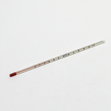 Das Bild zeigt ein Glasthermometer, das zur Messung von Temperaturen verwendet wird. Auf dem Thermometer sind Skalen von 0 bis 100 Grad Celsius abgebildet, und die Flüssigkeit im Inneren ist rot.