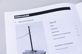 Das Bild zeigt eine Abbildung aus einem Lehrbuch, das sich mit dem Thema Elektrostatik beschäftigt, speziell mit dem Versuch zur Spitzenentladung. Auf der Seite sind die benötigten Materialien und deren Anzahl aufgelistet, um das Experiment durchzuführen.