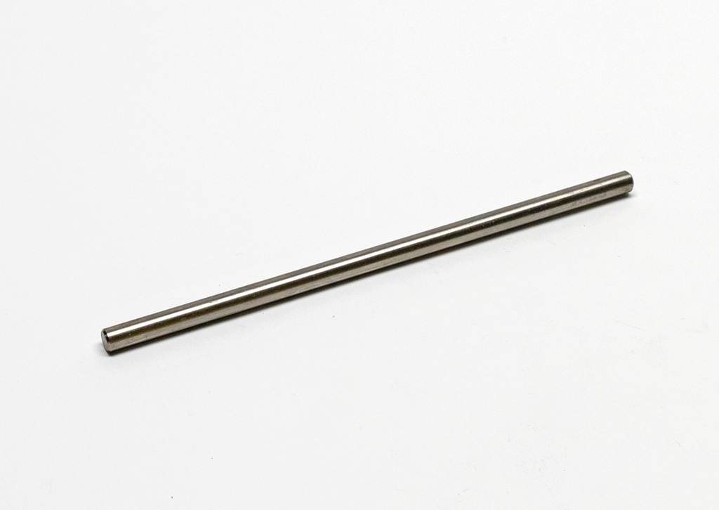 Das Bild zeigt einen langen, schlanken Metallstab, der auf einer weißen Oberfläche liegt. Er könnte als Experimentiermaterial in naturwissenschaftlichen Bildungseinrichtungen verwendet werden.