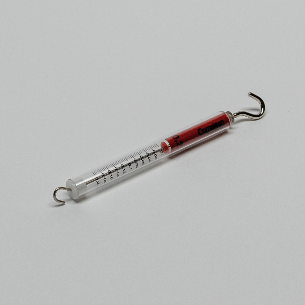 Das Bild zeigt ein Thermometer mit einer roten Flüssigkeit und einer Skala zur Temperatureinstellung. Es verfügt über einen Haken an einem Ende, wodurch es für Experimente im Bildungsbereich geeignet ist.