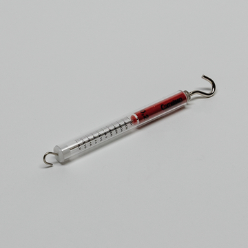 Das Bild zeigt ein Thermometer mit einer roten Flüssigkeit und einer Skala zur Temperatureinstellung. Es verfügt über einen Haken an einem Ende, wodurch es für Experimente im Bildungsbereich geeignet ist.