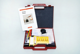 Das Bild zeigt eine rote Kunststoffbox mit Experimentiermaterialien für den Biologieunterricht. In der Box befinden sich verschiedene Werkzeuge und ein Handbuch mit Anleitungen für Experimentierprojekte.