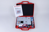 Das Bild zeigt einen roten Koffer, der einen Experimentierkasten für elektrische Grundschaltungen enthält. Neben verschiedenen Bauteilen und Schaltungen befindet sich ein Handbuch, das Anleitung und Unterstützung für die Durchführung von Experimenten bietet.