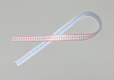 Das Bild zeigt ein flexibles Maßband, das auf einer neutralen Oberfläche liegt. Es ist auf der einen Seite blau und auf der anderen Seite rot, mit klaren numerischen Markierungen für präzise Messungen.