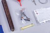 Das Bild zeigt verschiedene Experimentiermaterialien, darunter einen rot gefärbten Trichter, eine transparente Tüte mit Werkzeugen und eine gelbe Kapsel. Diese Utensilien sind für den Einsatz im Bildungsbereich gedacht und fördern praktische Experimente.