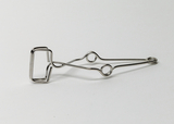 Das Bild zeigt eine metallene Klammer mit einem rechteckigen Greifmechanismus und zwei runden Öffnungen. Diese Klammer könnte für verschiedene Experimente im Bildungsbereich verwendet werden, um Materialien zu fixieren oder zu halten.