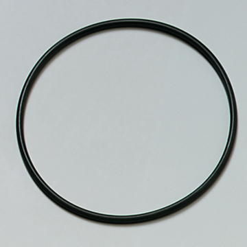 Das Bild zeigt einen schwarzen, kreisförmigen Ring, der auf einem hellen Untergrund liegt. Er könnte aus Kunststoff oder Gummi bestehen und wird möglicherweise für experimenzielle Zwecke im Bildungswesen verwendet.