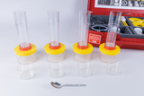Das Bild zeigt ein Experimentier-Set mit zwei transparenten Röhren auf gelben und roten Basen sowie mehreren kleinen Behältern und einem Löffel. Es scheint für wissenschaftliche Untersuchungen im Bildungskontext, speziell zu Bodentypen und Pflanzenwachstum, konzipiert zu sein.
