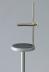 Das Bild zeigt ein Experimentiergerät, das aus einem stabilen Standfuß und einem senkrechten Metallstangen besteht. An einer horizontalen Stange sind verschiedene Halterungen angebracht, die für chemische oder physikalische Experimente genutzt werden können.