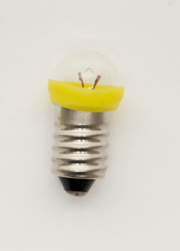 Das Bild zeigt eine kleine Glühbirne mit einem metallischen Gewinde und einer transparenten Glasabdeckung. Der obere Rand der Birne ist gelb und enthält zwei sichtbare Drähte, die die elektrische Verbindung herstellen.