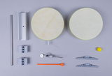 Das Bild zeigt eine Sammlung von Experimentiermaterialien, darunter zwei runde Platten, metallische und Kunststoffkomponenten sowie kleine Abstände und Halterungen. Diese Werkzeuge scheinen für praktische Experimente im Bildungsbereich konzipiert zu sein.