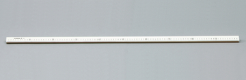 Das Bild zeigt ein gerades Lineal, das auf einer grauen Unterlage liegt. Es ist in Zentimetern und Millimetern skaliert und dient als präzises Messwerkzeug für experimentelle Zwecke im Bildungsbereich.
