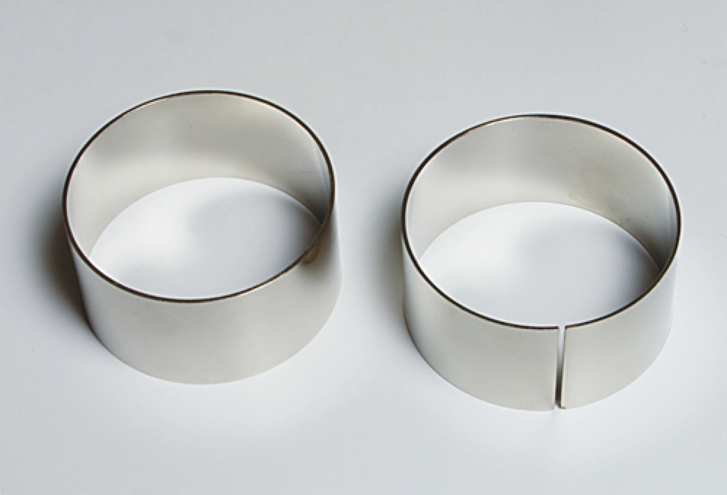 Das Bild zeigt zwei metallene Ringe, die für Experimente verwendet werden können. Der linke Ring ist vollständig, während der rechte Ring eine ausgeschnittene Öffnung hat, was unterschiedliche Einsatzmöglichkeiten bei Experimenten ermöglicht.