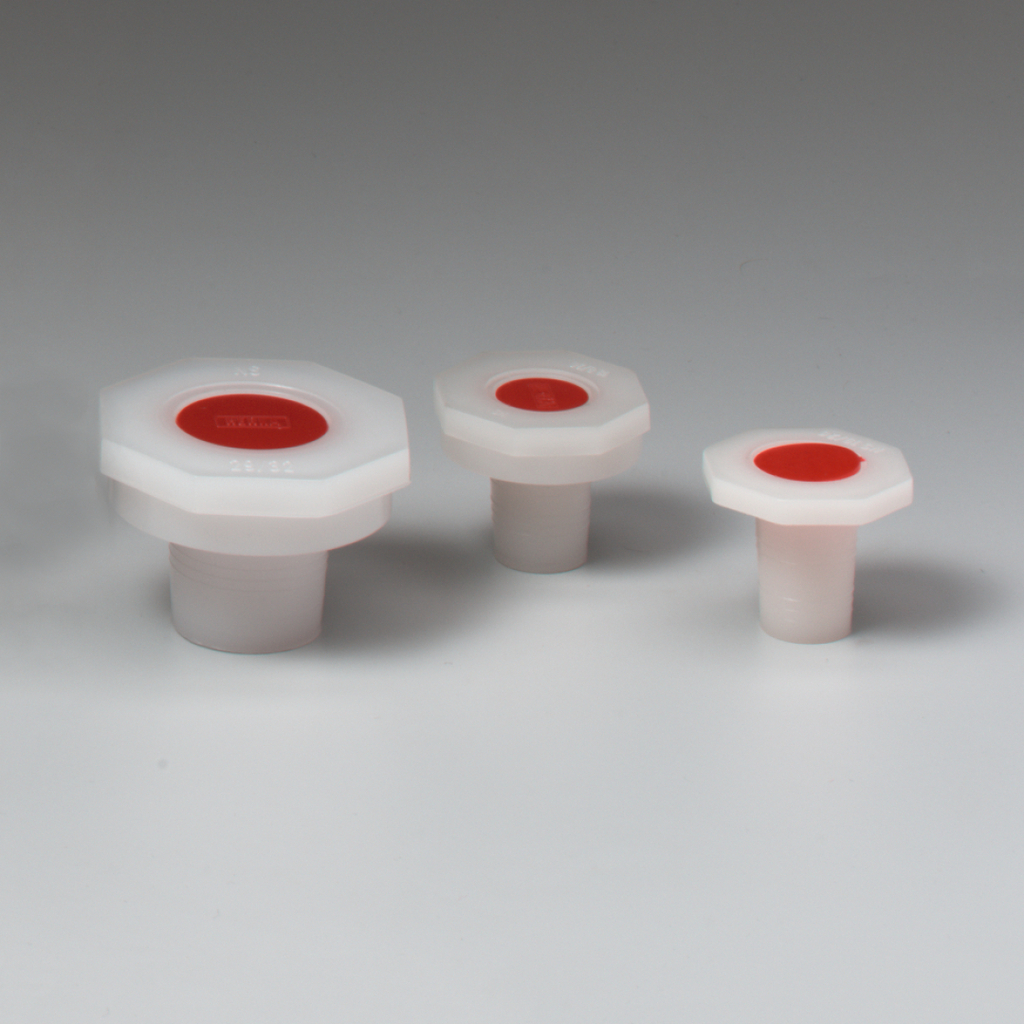 Das Bild zeigt drei verschiedene Größen von weißen Kunststoffstopfen mit roten Oberflächen. Diese Stopfen sind für den Einsatz in Experimenten und im Bildungseinrichtungen konzipiert, um Flüssigkeiten sicher abzuschließen.