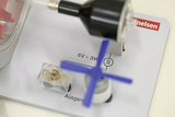 Das Bild zeigt ein Experimentiergerät, das aus verschiedenen Komponenten wie einem Motor, einem Schalter und einer Kennzeichnung für die Stromversorgung besteht. Die Beschriftungen geben wichtige technische Informationen über Spannung und Leistung des Geräts an.