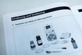 Auf der Abbildung sind verschiedene Materialien zur Durchführung eines Experimentes zum Nachweis von Stärke in Lebensmitteln zu sehen. Dazu gehören Zucker, Grieß, verschiedene Proben in Schalen sowie einige Laborinstrumente wie Pipetten und Löffel.
