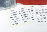 Auf dem Bild sind verschiedene Etiketten für chemische Substanzen zu sehen, die im Unterricht verwendet werden können. Die Etiketten beinhalten Namen und Hinweise zur Verwendung von Stoffen wie Alu-Kristallen, Essigsäure und Brennspiritus.