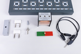 Verschiedene elektrische Komponenten und Materialien für Experimente zur Elektrizität sind auf einem weißen Untergrund angeordnet. Zu sehen sind ein Transformator, Steckverbinder, Kabel und ein Schalter, die sich für den schulischen Einsatz eignen.