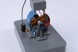 Ein Elektromotor ist abgebildet, bestehend aus einer rotierenden Spule und einem feststehenden Magneten. Das Gerät veranschaulicht die Funktionsweise des Elektromagnetismus und ist ideal für Experimente im Bildungsbereich.
