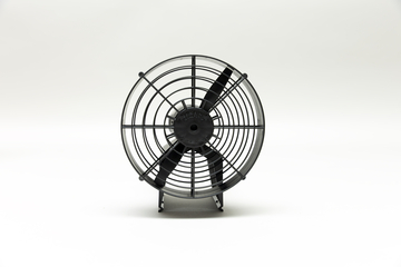 Ein schwarzer Ventilator mit Schutzgitter steht zentral vor einem weißen Hintergrund. Das Gerät ist für den Einsatz in wissenschaftlichen Experimenten konzipiert.
