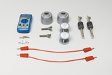 Ein blaues Multimeter liegt neben verschiedenen metallischen Bauteilen, Spulen und zwei roten Verbindungskabeln. Das Set umfasst zudem Krokodilklemmen sowie isolierte Kontaktstifte für physikalische Experimente.