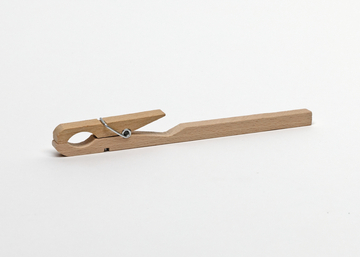 Eine hölzerne Wäscheklammer liegt horizontal auf einem weißen Hintergrund. Das schlichte Utensil besteht aus zwei Holzleisten und einer Metallfeder.