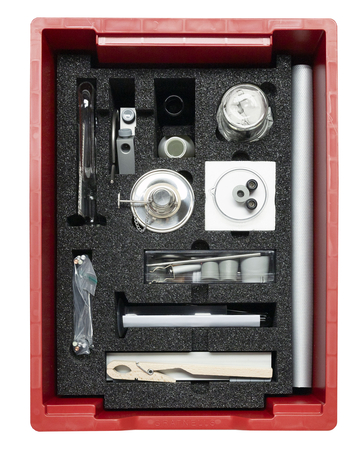 Ein roter Koffer enthält ein Set an wissenschaftlichen Instrumenten, die passgenau in schwarzen Schaumstoff eingebettet sind. Das Set umfasst unter anderem Glasgefäße, Messwerkzeuge und Zubehör für physikalische oder chemische Experimente.